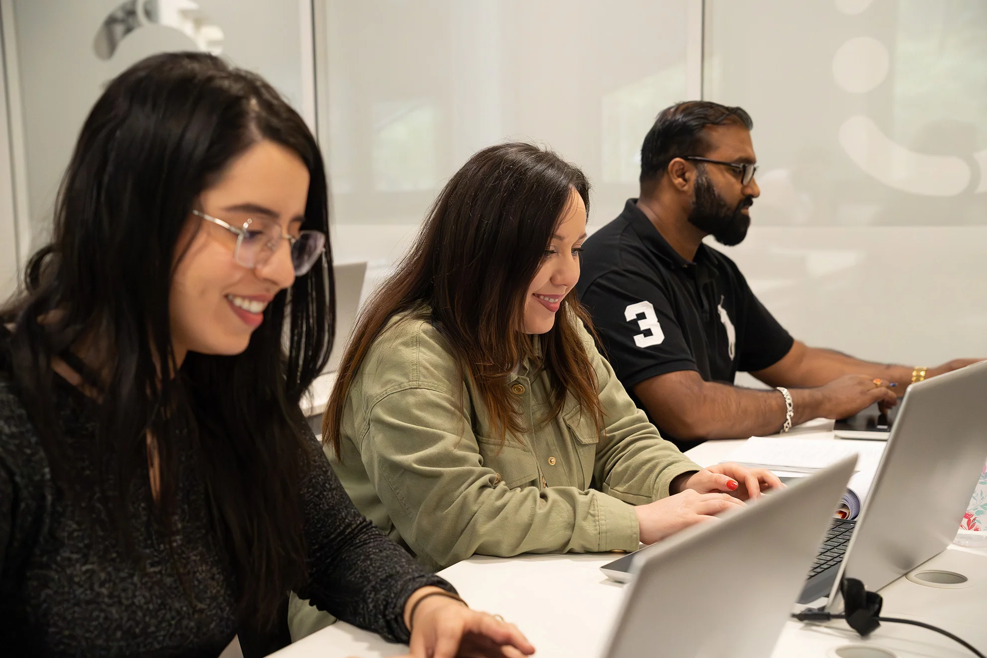 Trois apprenants heureux de leur cours en présentiel